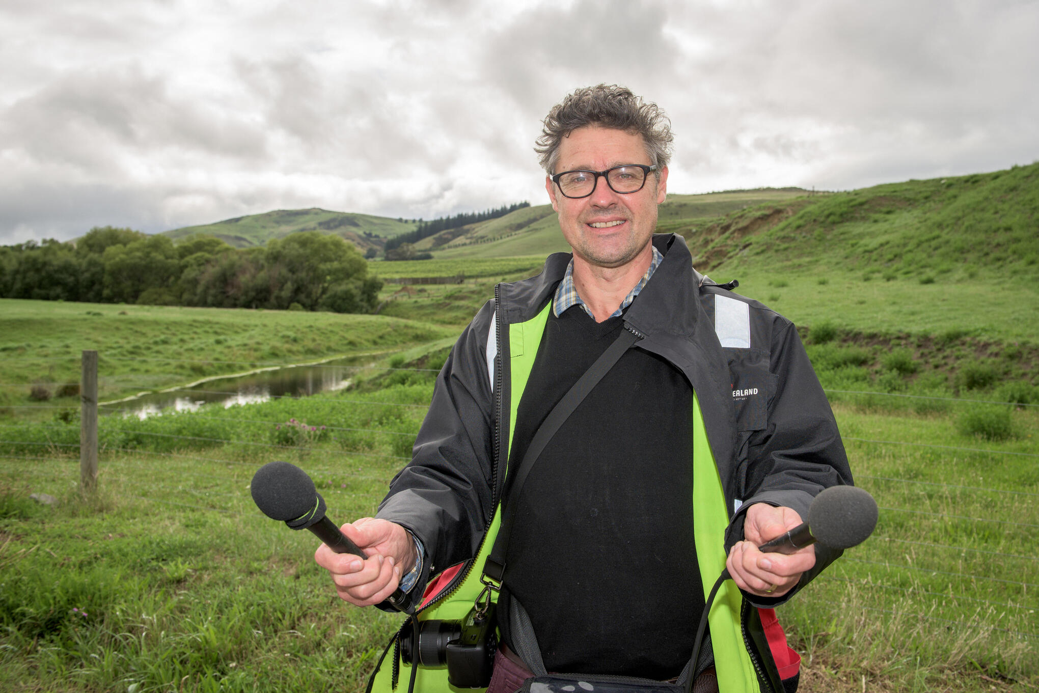 Cosmo Kentish-Barnes holding two microphones outdoors